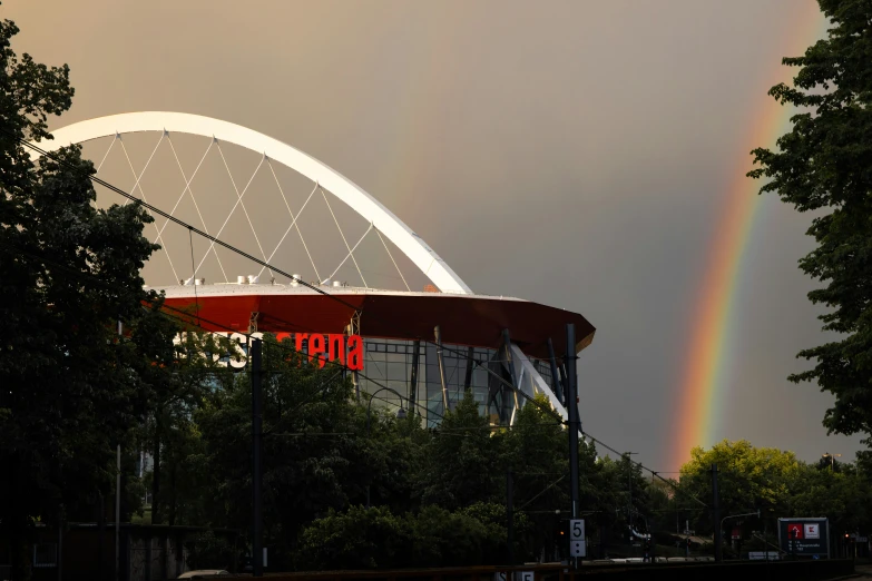 the rainbow is seen behind the building near trees