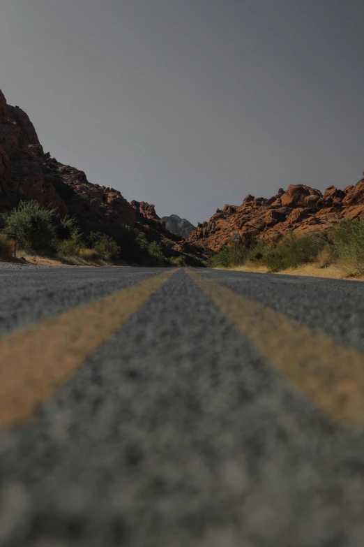 the yellow line in the road is next to a mountain