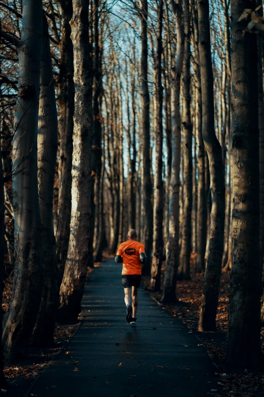 the man is running through the forest in his red jacket