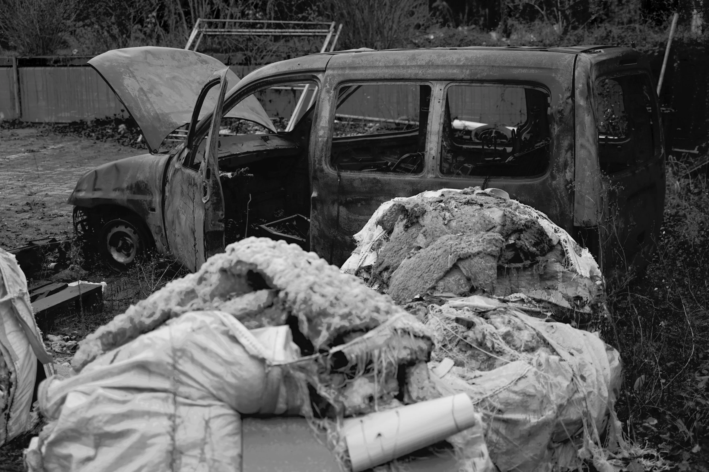 a destroyed truck and some buildings with it's hood up