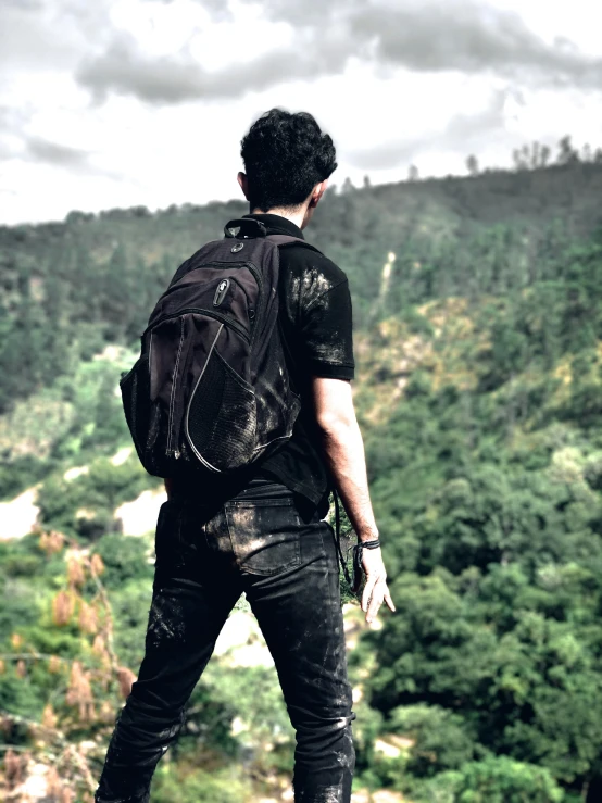 a man is staring out over some forested hills