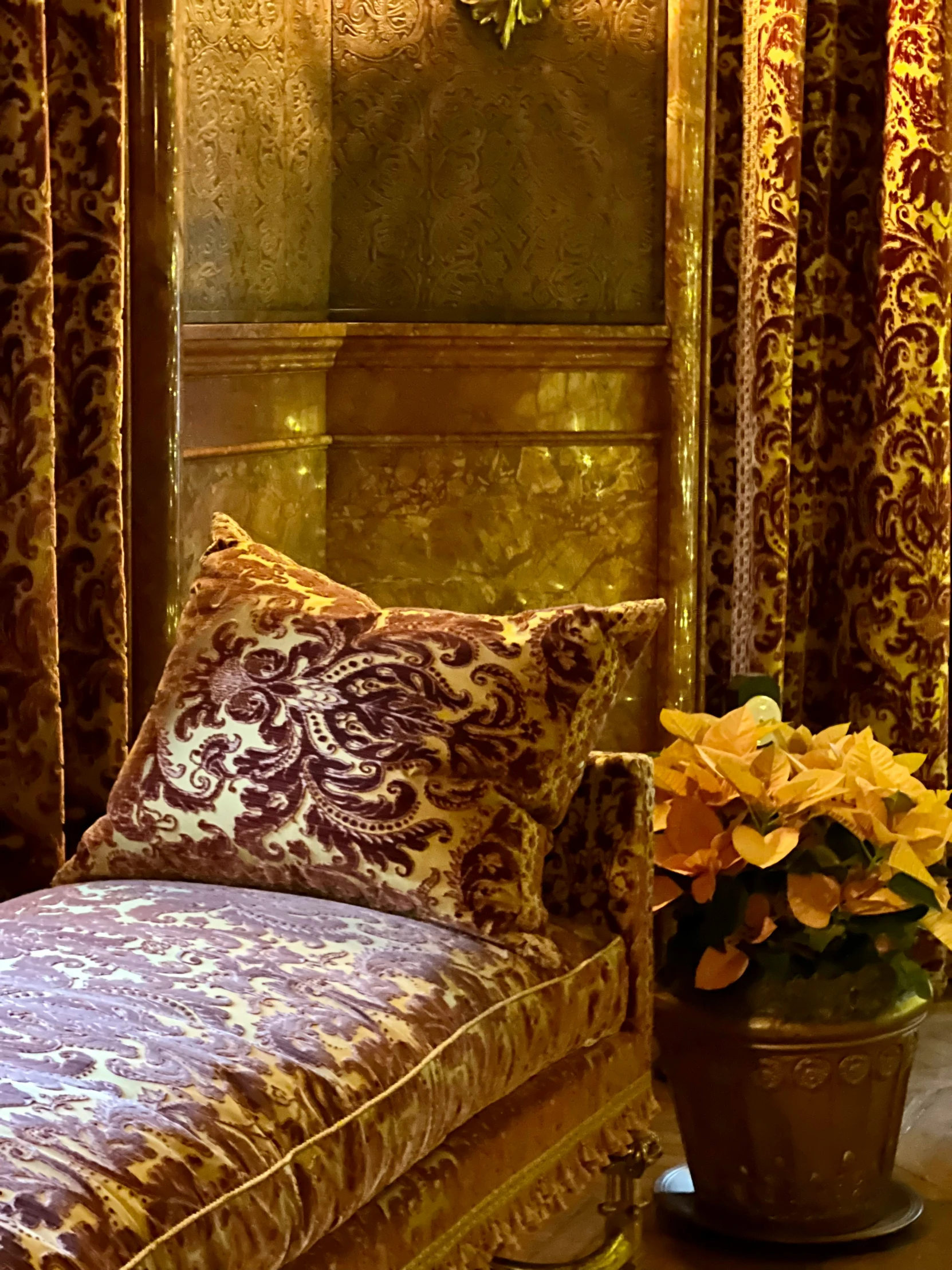 decorative furniture and pillows sitting on a table in front of a mirror