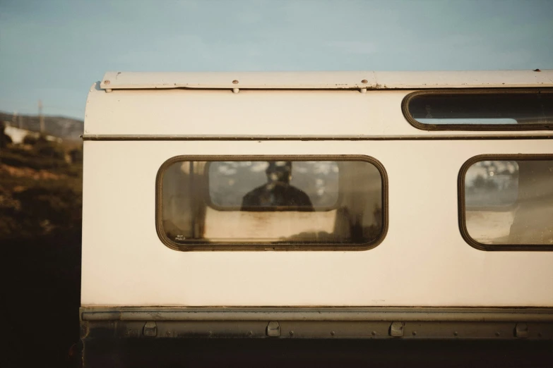 the rear window of a bus showing a man with a beard