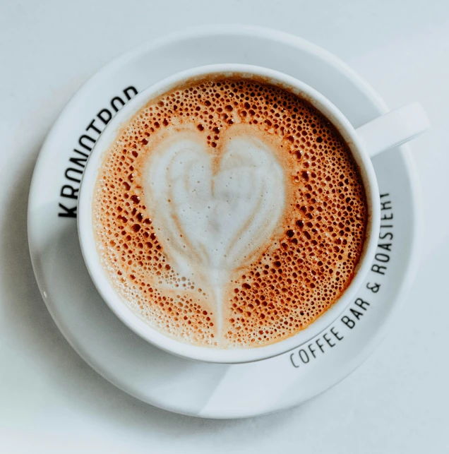 a cup of coffee is displayed with an intricate heart