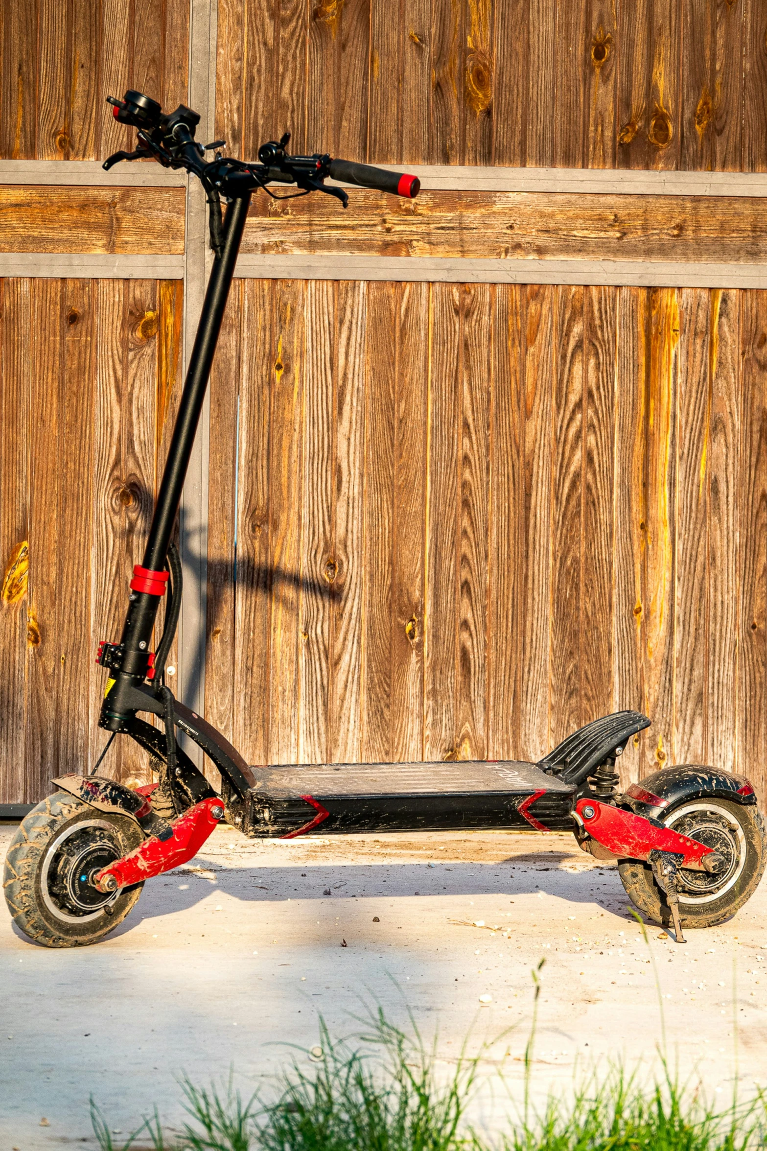 a scooter is leaning against a wooden fence