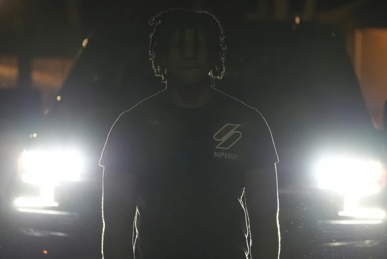 a young man standing next to two lights