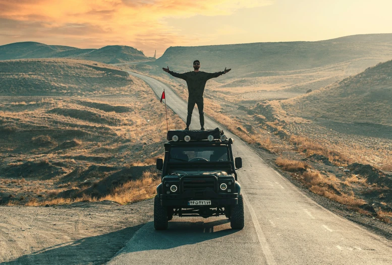 there is a man that is on top of a jeep