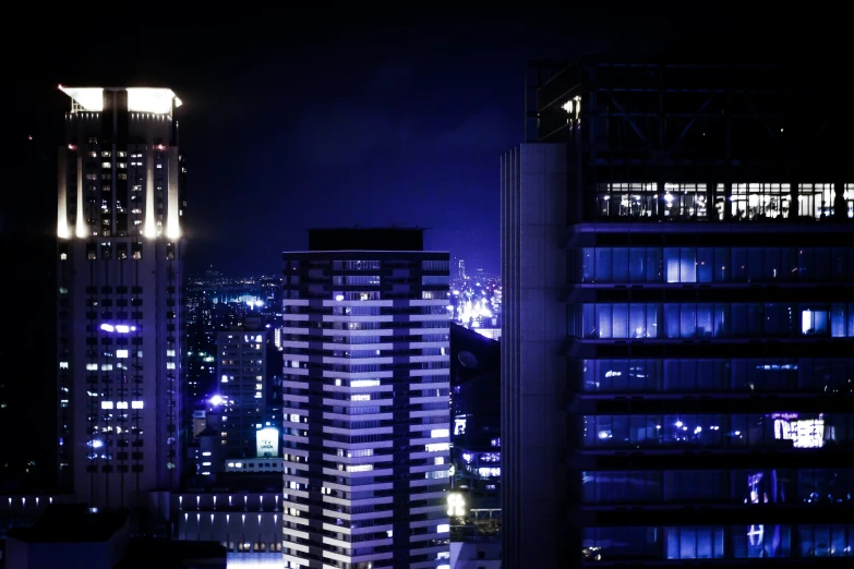 a view of some tall buildings in the city at night