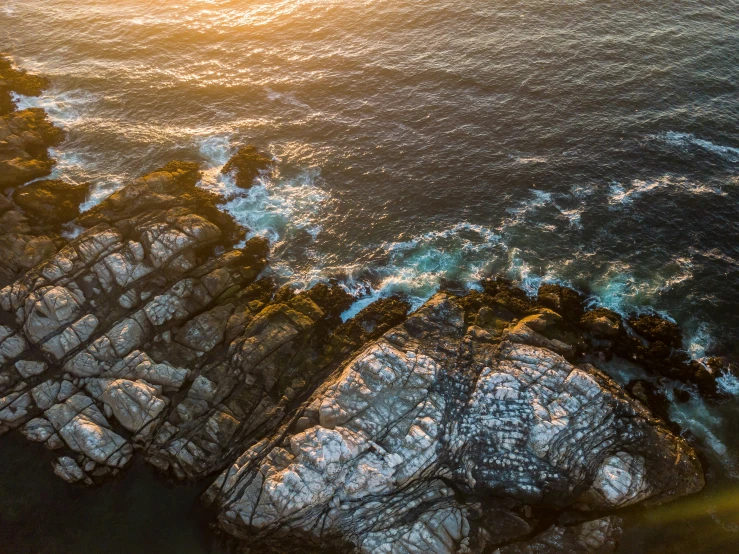 several rocks on the ocean shore near the beach