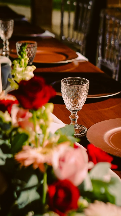 long dining table set with roses and gold place settings