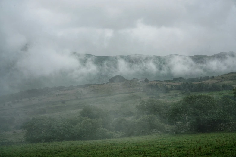 clouds in the air over a field and a mountain range