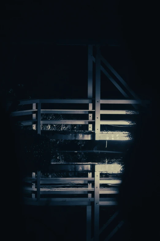 a wooden bench next to water and an overexposed background