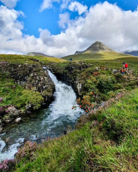 two people trekking through an open valley