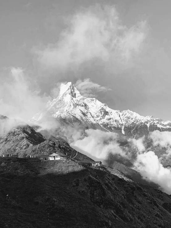 clouds cover the mountain top in a black and white po