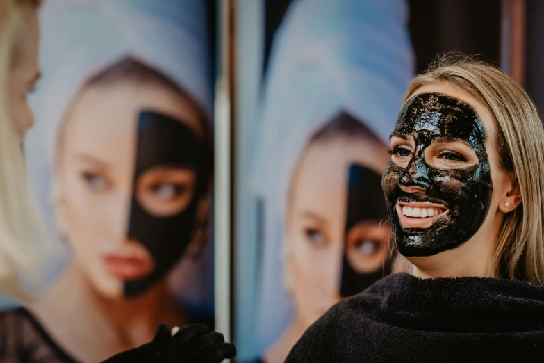 a beautiful blonde woman putting on a black face mask