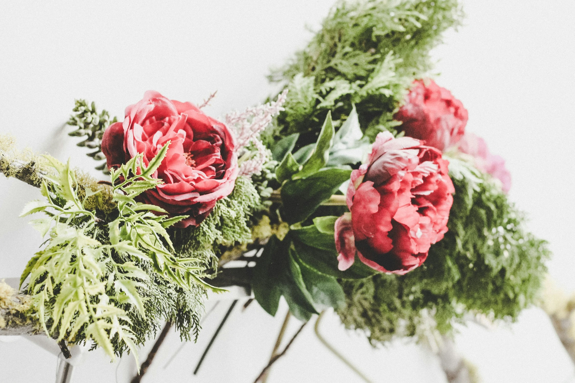 three bouquets of different flowers are in a vase