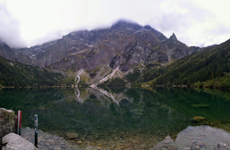 the mountain is behind the lake and there are trees