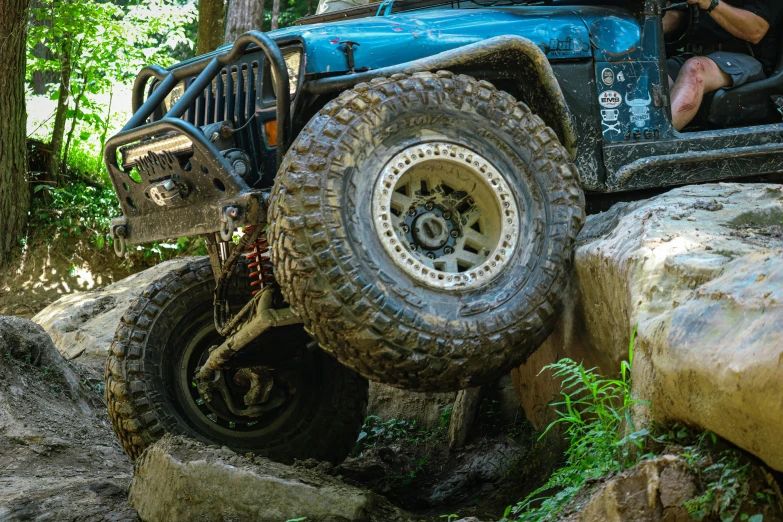 a guy that is riding on the back of a blue jeep