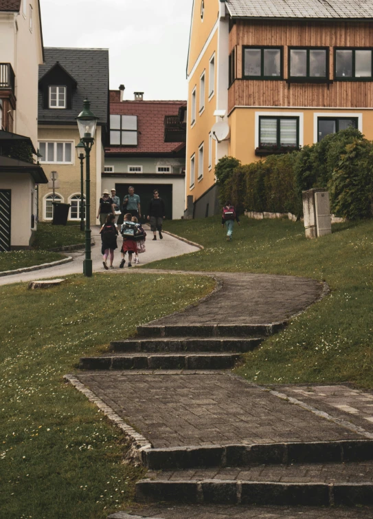 the people are walking in the city near a bunch of houses