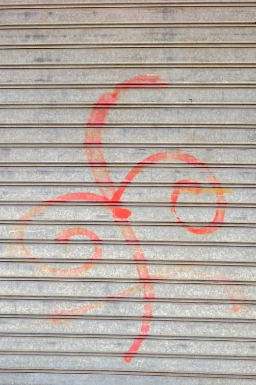 a red stencil of a cat sitting on a blue and white tiled wall