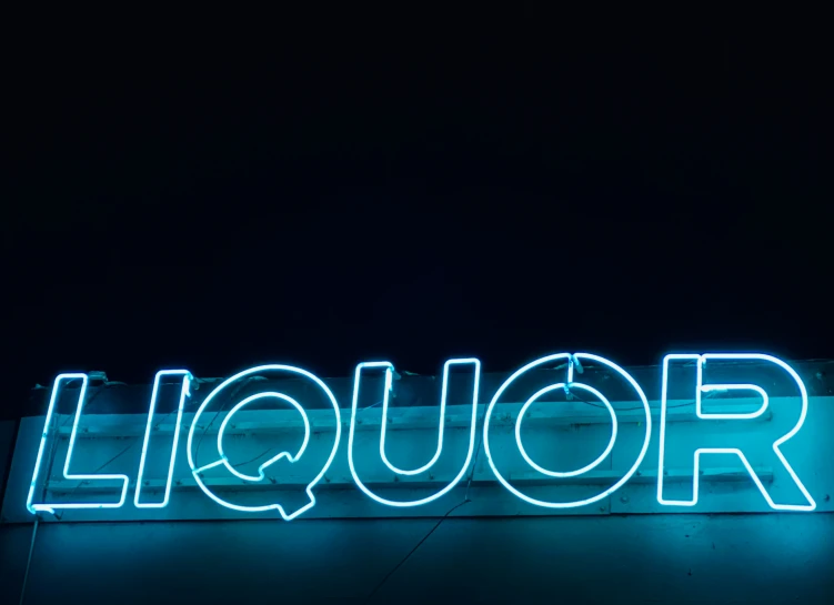 a large liquor neon sign that is lit up in the dark