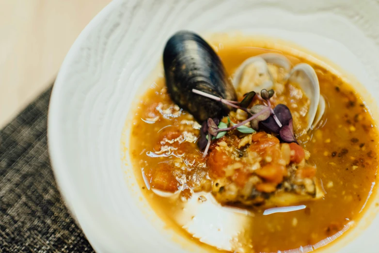 a bowl filled with soup sitting on top of a white plate