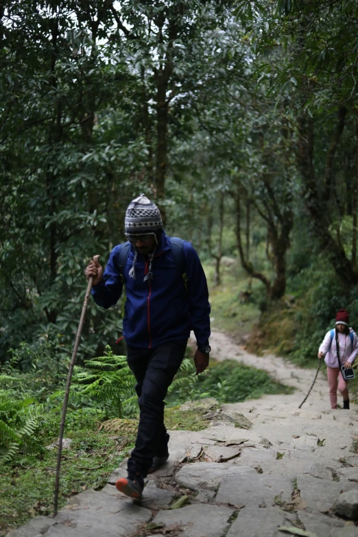 people wearing helmets are hiking down the dirt trail