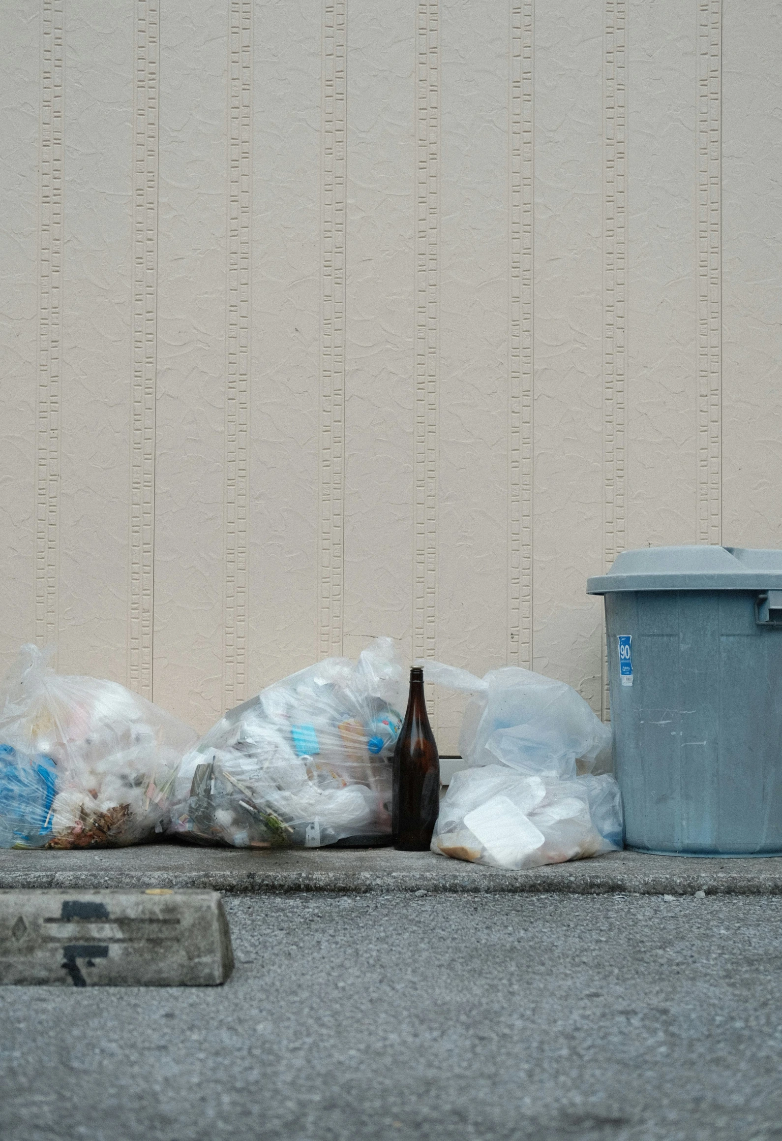 a close up of trash on the street near the wall