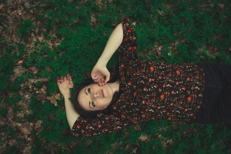 a woman laying on her stomach holding a phone