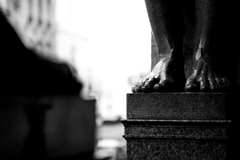 the foot of a statue in front of a building