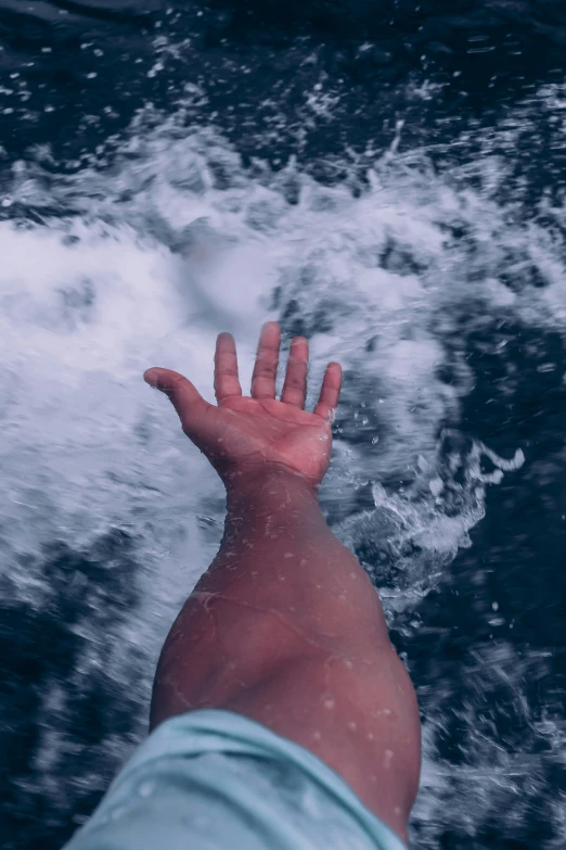 an image of hand reaching out into the water