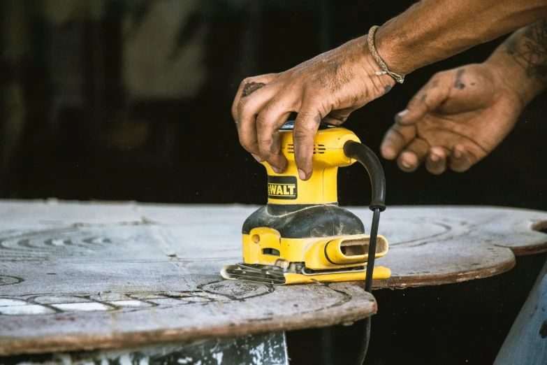 a person using an electric hand tool on a skateboard