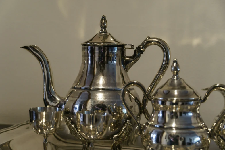 a silver tea pot and a silver coffee pot