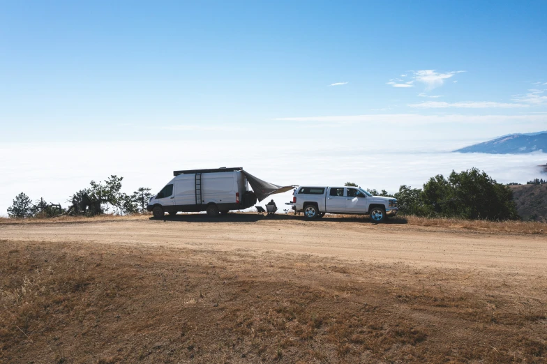 some pickups are parked near a small truck