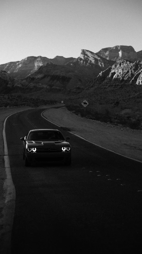 a car is driving on the road in front of mountains