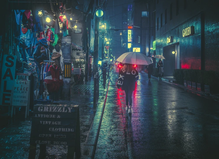 a person walking on a city street at night with an umbrella