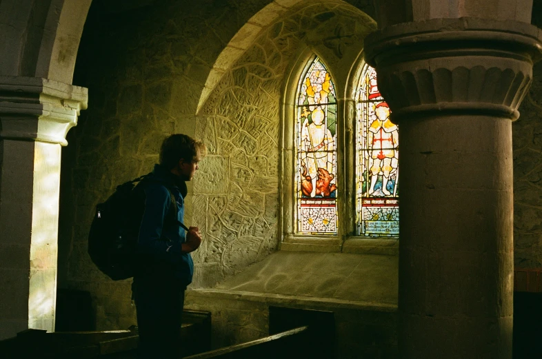 a person is looking at stained glass windows