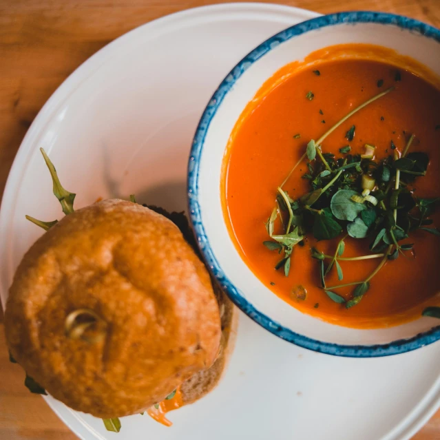 a bowl of soup and a piece of bread on a plate