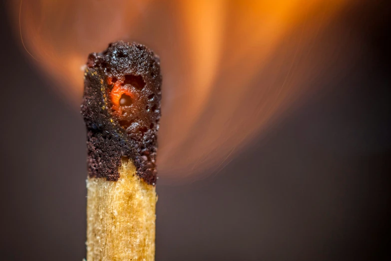 a close up of a match stick that has some fire on it