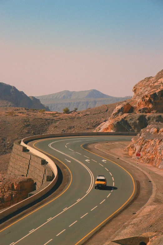 a yellow truck driving on a winding road