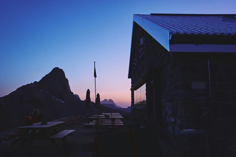 some picnic tables and umbrellas near mountains