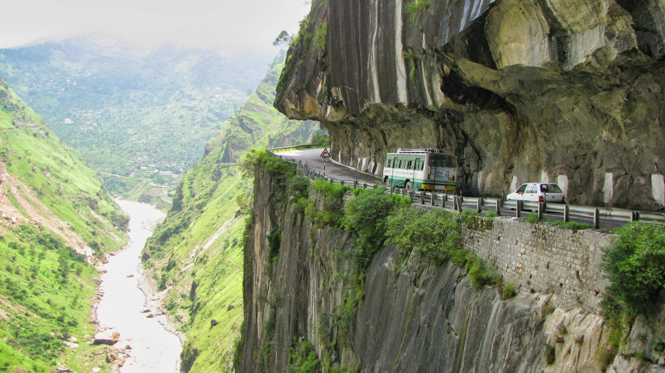 cars are on a road on top of cliffs