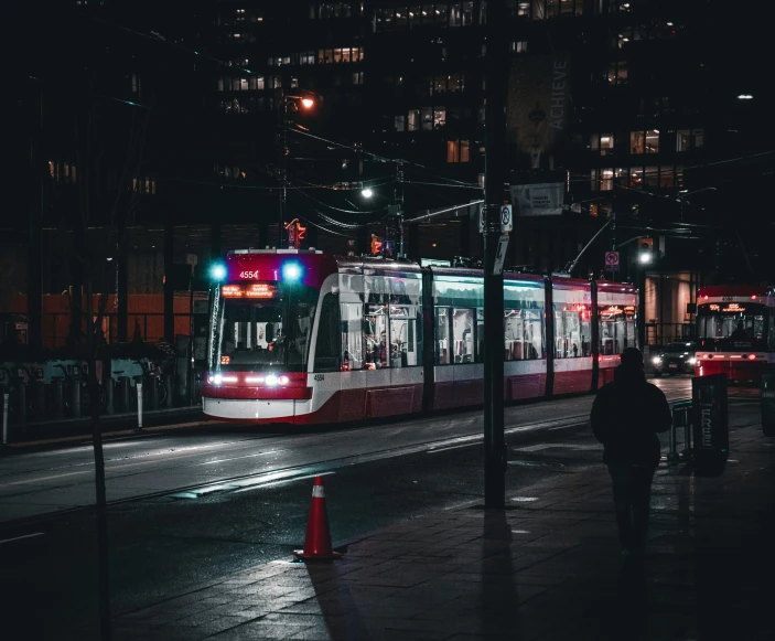 a night view of a tram traveling down the street