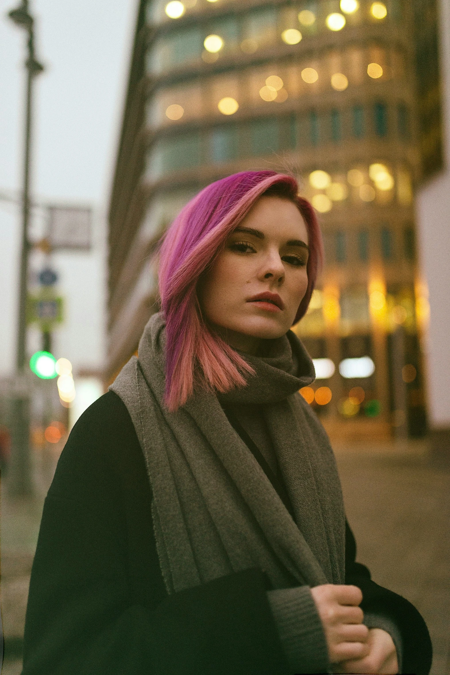 a girl with a pink bobble hair, standing in the street