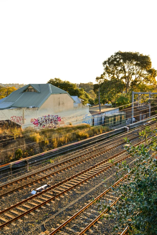 an abandoned building sits in the middle of train tracks