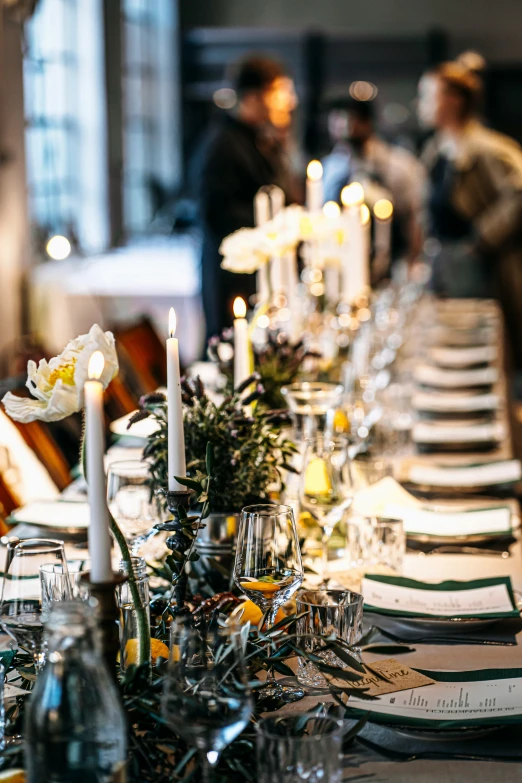 a table with lots of white dinner plates with silver utensils