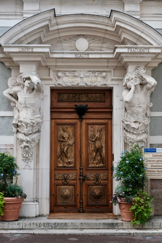 two statues stand next to each other in front of an ornate door