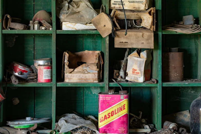 the inside of a green wooden shelf filled with items