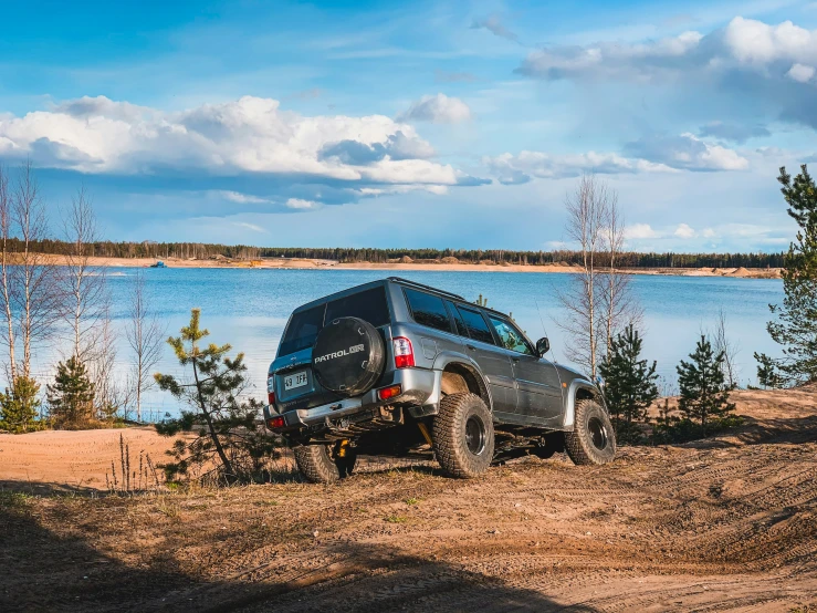 a truck is parked by the side of a lake