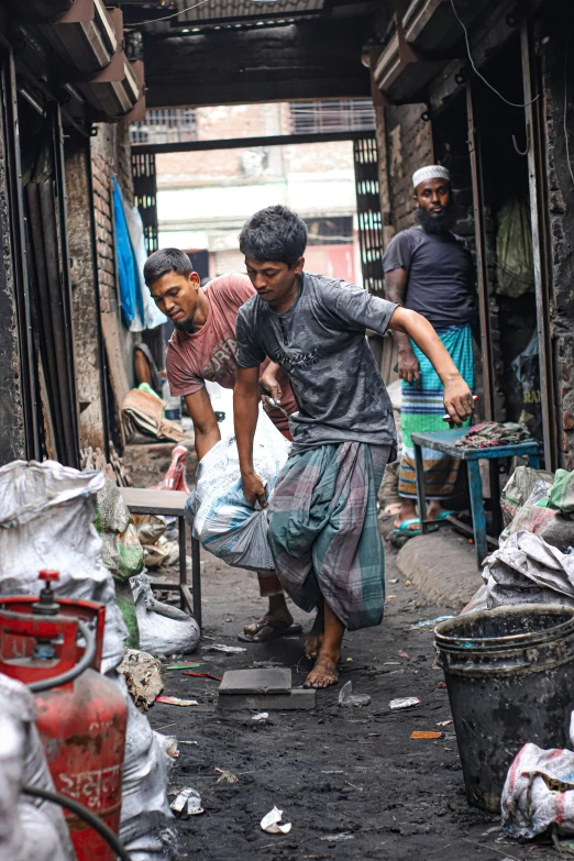 three people are standing by some trash can't